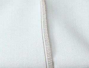 Detail of precise double stitching and overlock edge on striped mini dress fabric