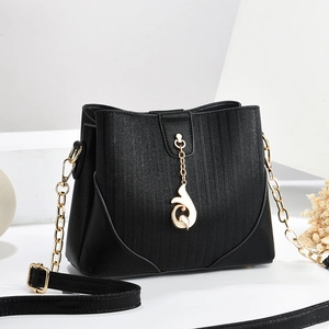Elegant black pebble leather bucket bag with gold chain and luxury fox charm accessory