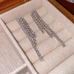 Detail of silver long tassel earrings with sparkling crystals in a jewelry box