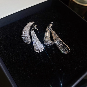 Macro shot of silver zircon tassel earrings featuring square hollow geometric design