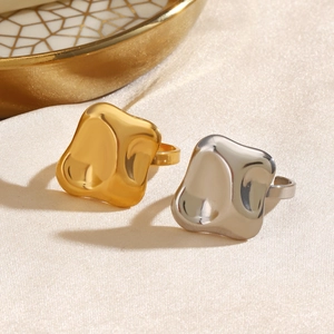 Minimalist geometric hammered rings in gold and silver finish on a textured beige fabric
