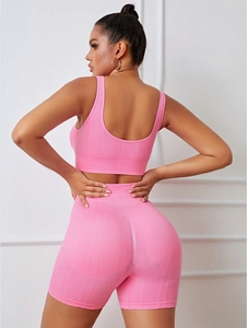 Detail of pink ribbed knit texture on high-waist sports shorts and athletic bra set