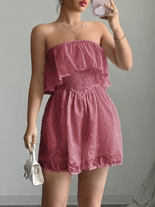 Dettaglio della tuta strapless rosa con tessuto testurizzato e vita elastica aderente