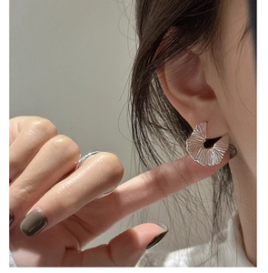 Detailed view of S925 sterling silver pleated fan earrings with textured finish