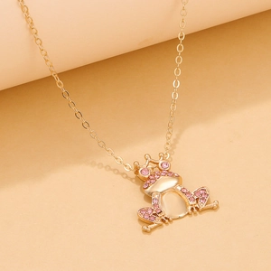 Macro shot of crown frog pendant necklace with pink rhinestones and opal stone