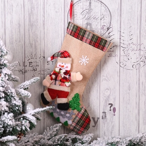Detail of Christmas stocking with 3D snowman doll on rustic wooden background