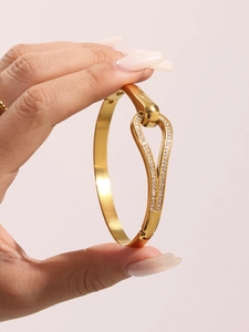 Dettaglio del bracciale a goccia in acciaio dorato con micro-pavé di zirconi bianchi brillanti