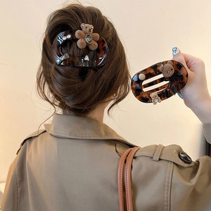 Tortoiseshell claw clip with flocked bear and rhinestone accents on elegant hair