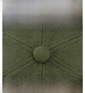 Detailed macro view of the top button and stitching on this dark green cotton docker hat