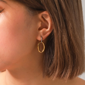 Minimalist oval hoop earrings in two-tone gold and silver finish shown on model