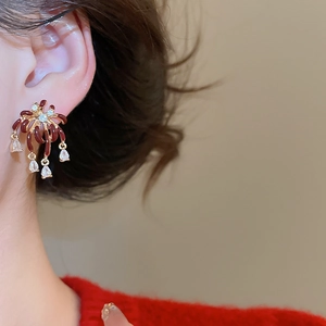 Close-up of vintage gold-plated drop earrings with burgundy enamel and cubic zirconia