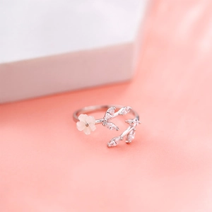 Close-up of S925 sterling silver open ring with white flower and zircon leaf detail