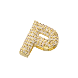 Macro detail of gold-plated letter P pendant pavé-set with clear cubic zirconia crystals