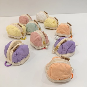 Macro view of multiple pastel quilted mini pouches for Airpods and small accessories