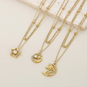 Detail of 18K gold-plated double-layer necklaces with star, moon and unicorn charms