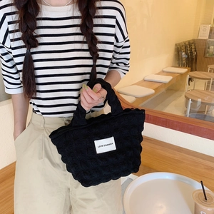 Detail of black bubble textured tote bag with LOVE SOZAKKA woven label and zipper closure