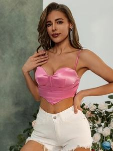 Détail d'un haut court corset en satin rose avec fines bretelles et finition brillante