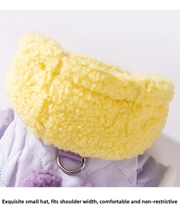 Close-up of quilted pet coat with fleece hood, D-ring leash attachment and pompom detail