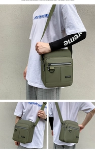Detail view of military green crossbody bag with multiple zip compartments and durable fabric