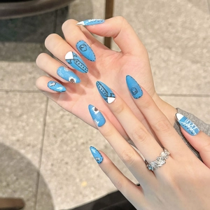 Handmade stiletto press-on nails featuring light blue denim patterns and hand-painted stitching