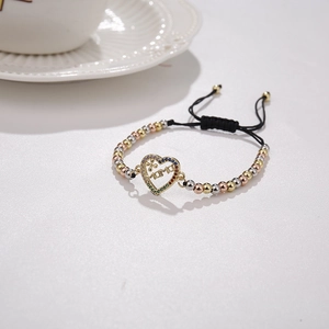 Detail of adjustable black woven bracelet with three-tone MAMA heart beads in 18K gold plating