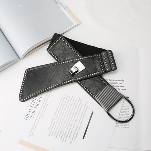 Punk style wide elastic waist belt with metal studs and silver buckle on magazine background