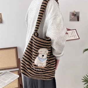Close-up of fluffy striped tote bag with a cute cartoon puppy patch and wide shoulder strap