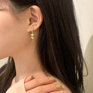 Detail of gold rose pendant earring and twisted ear cuff set on model's ear