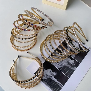Close-up of baroque hairbands with sparkling rhinestones and white pearls on gold metal frame