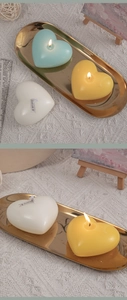 Macro detail of heart-shaped scented candles in tiffany blue, yellow and white on a tray