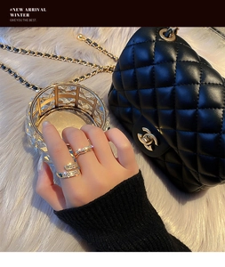 Close-up of gold-plated rings with layered diamond-encrusted design and wave texture