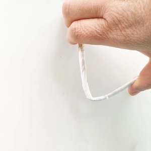 White flexible glitter stems for Christmas DIY decor being hand-bent for shaping