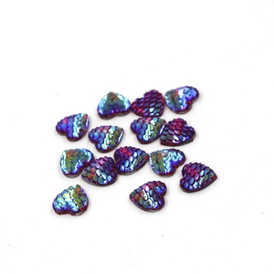 Close-up of heart-shaped iridescent fish scale resin charms for DIY jewelry making