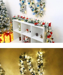Detailed flocking Christmas garland with warm LED lights, pinecones and red bows