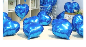 Blue heart-shaped foil balloon scattered in a cozy room setting for party decoration