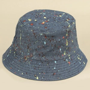 Détail d'un chapeau bob en denim bleu avec motif graffiti d'éclaboussures de couleur