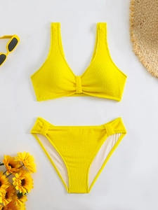 Close-up of yellow textured bikini with honeycomb fabric and summer beach accessories