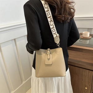 Chic khaki bucket bag for women featuring a wide patterned strap and golden hardware