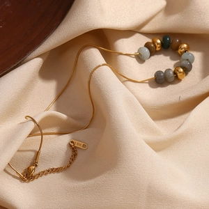 Détail du collier chaîne serpent plaqué or 18K avec perles en pierre naturelle sur soie