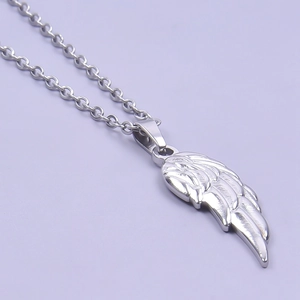 Close-up of a silver stainless steel wing pendant necklace with polished finish
