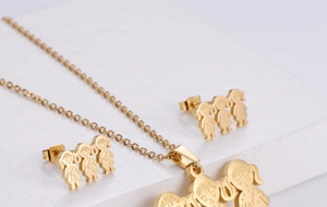 Detail view of gold titanium steel set featuring three cartoon girl pendants on white props