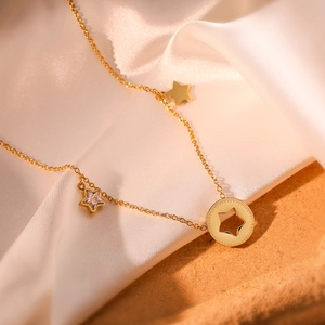 Elegant gold star pendant necklace featuring polished charms on creamy silk texture