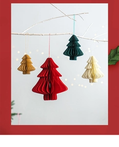 Detailed view of honeycomb paper Christmas tree ornaments hanging on white branches