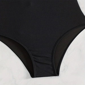 Close-up of black ribbed texture fabric and detailed stitching on one-piece swimsuit