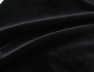 Vue macro de la texture du velours noir montrant des plis doux et un éclat subtil
