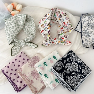 Collection of linen-cotton square scarves with floral and paisley prints on white backdrop