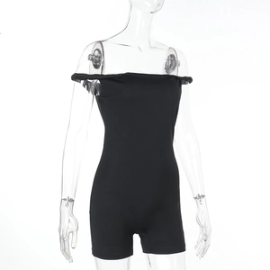 Dettaglio della tuta nera con spalle scoperte e nodo, taglio slim fit in tinta unita