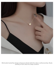 Detail view of S925 sterling silver butterfly pendant necklace on a female model