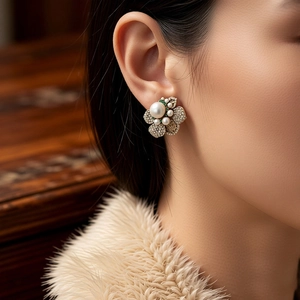 Detail view of vintage style flower stud earrings with pearls and diamond crystals