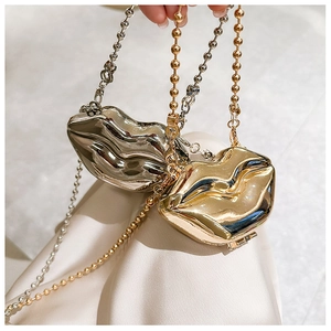 Detailed close-up of metallic lip-shaped mini bags in silver and gold with bead chains